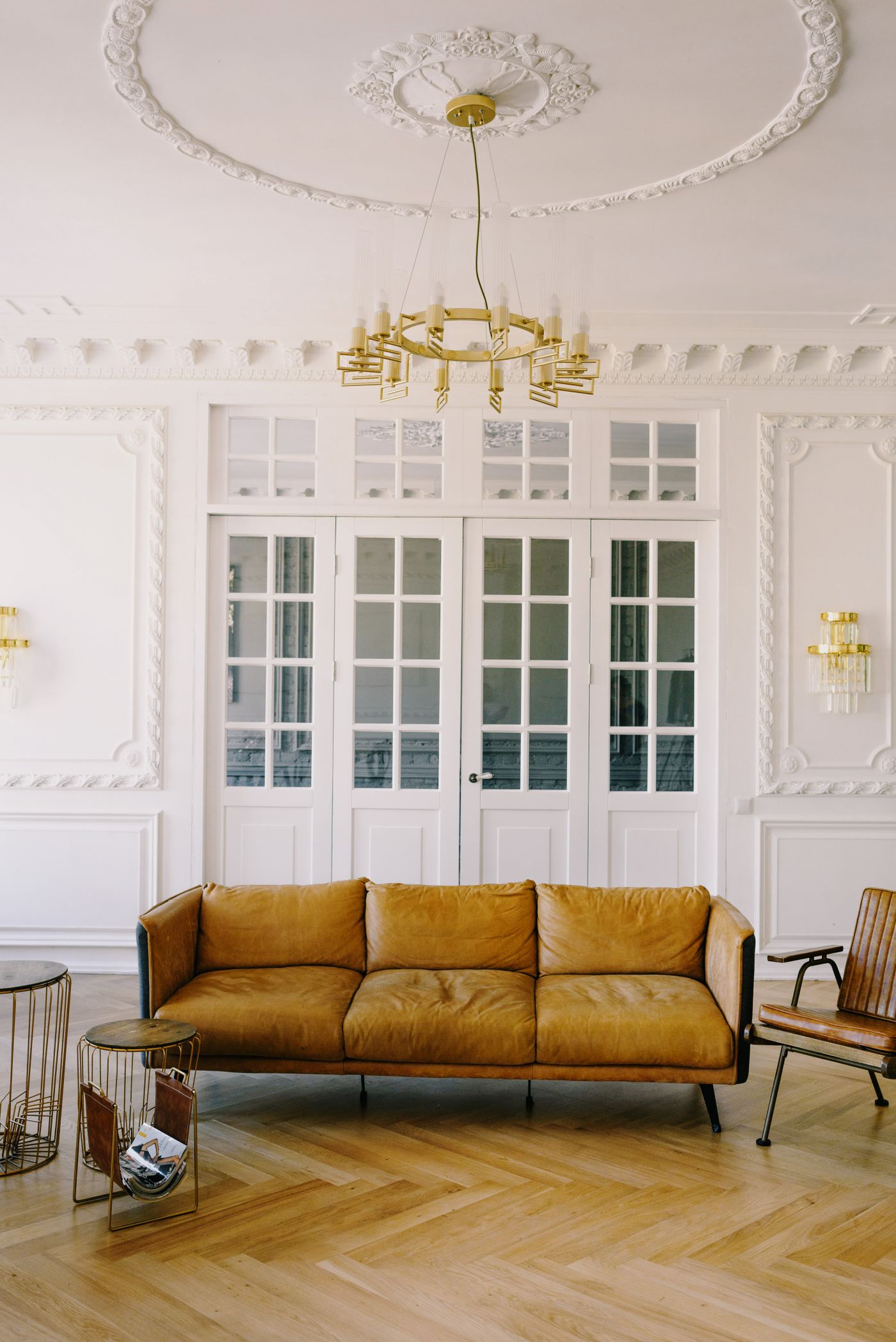 Salon d'un appartement ancien à Paris : moulures, portes vitrées, lustre et lumière du jour